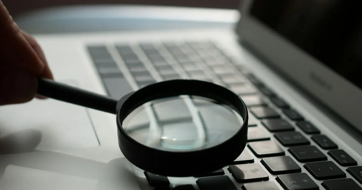 Magnifying glass held over a laptop keyboard