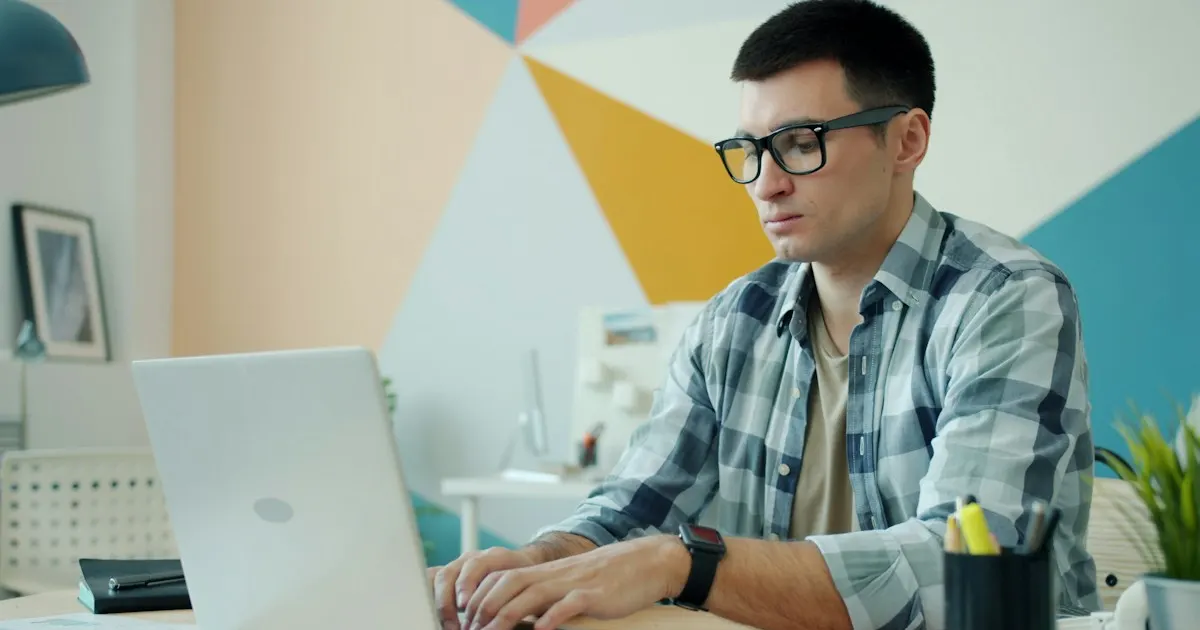 IT professional typing on a laptop at his desk